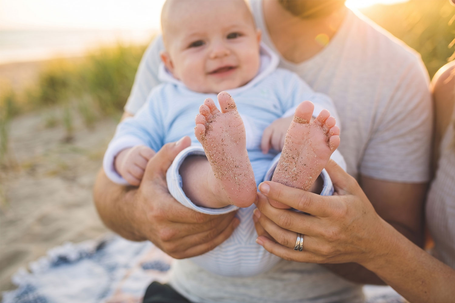 happy baby and parents on the beach
